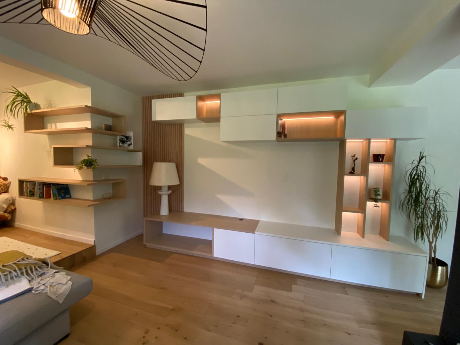 Aménagement mural de salon sur mesure avec niches éclairées et rangements intégrés